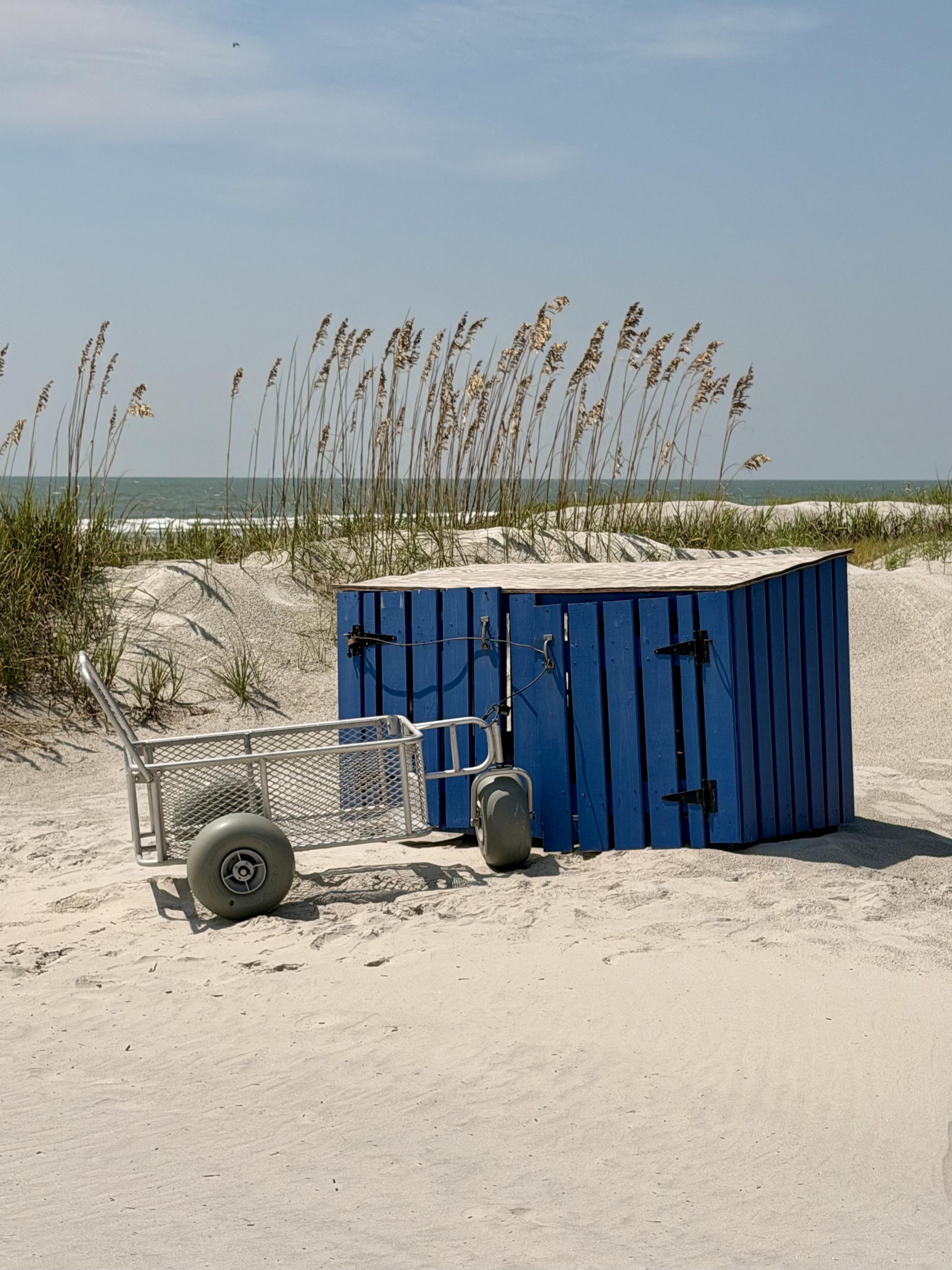 Storage bin and cart becoming buried in sand dunes.