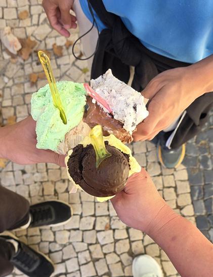 Three ice creams held by three people.