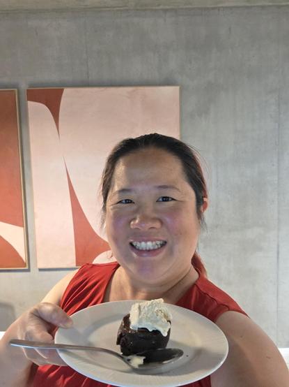 Mariatta holding a plate of lava cake topped with a scoop of ice cream