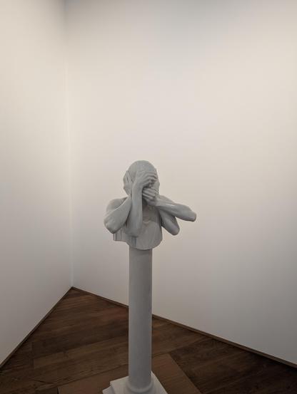 Marble sculpture of a head with multiple hands covering ears, mouth and eyes
