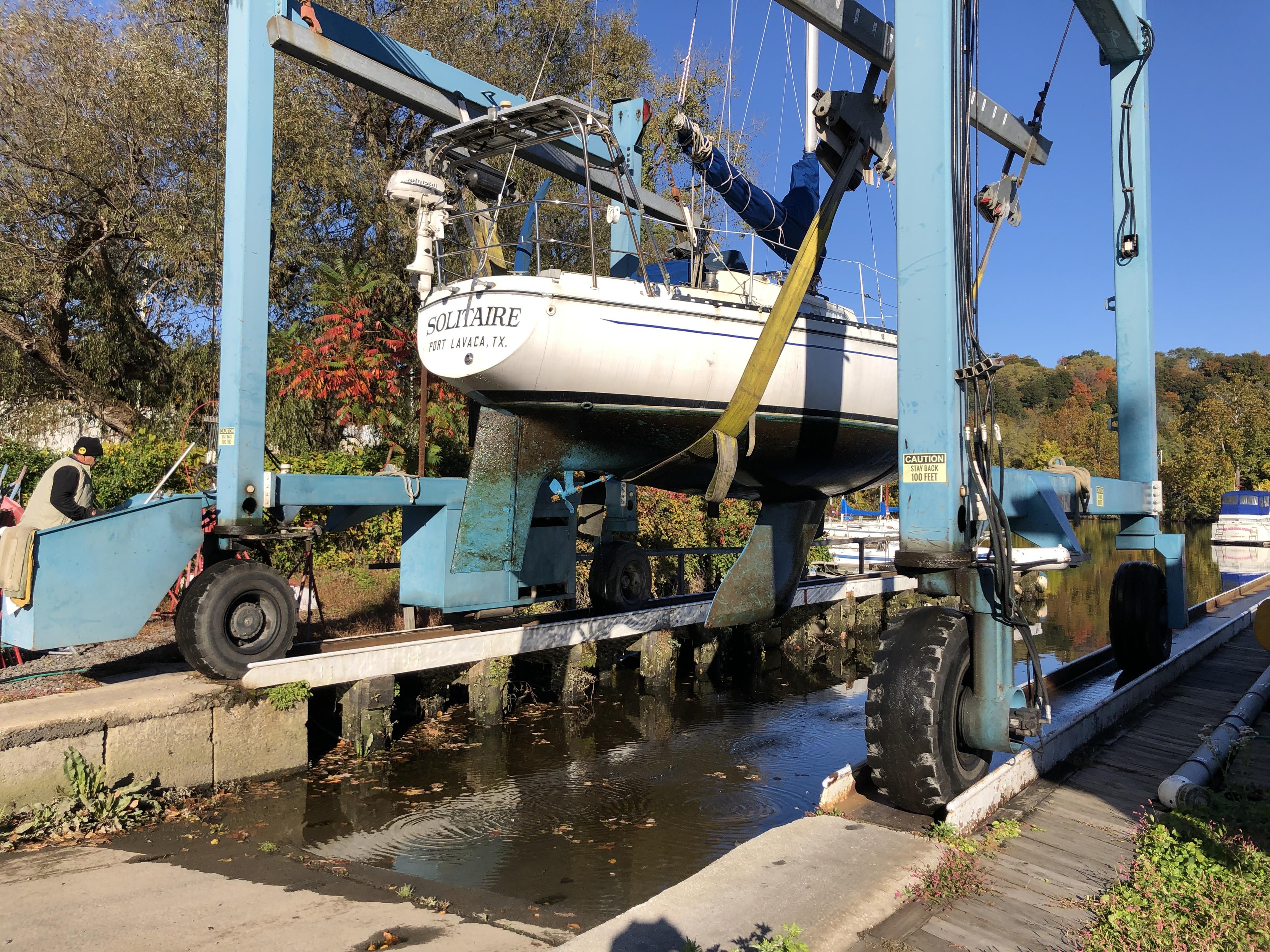 Solitaire in the travel lift being lifted out of the water