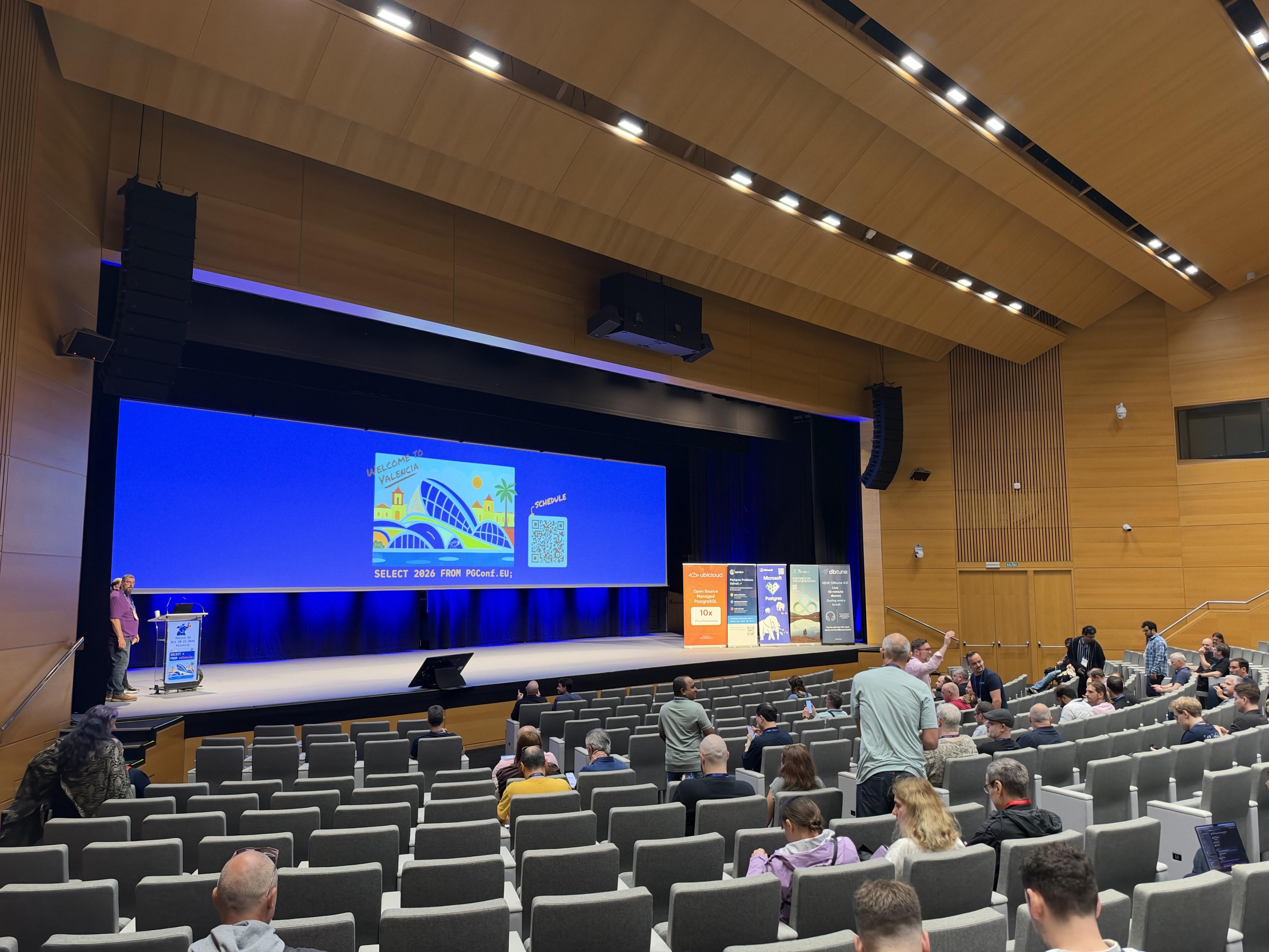 A keynote stage from reg pgconfeu in Valencia with the picture saying SELECT 2026 FROM pgconf.eu;