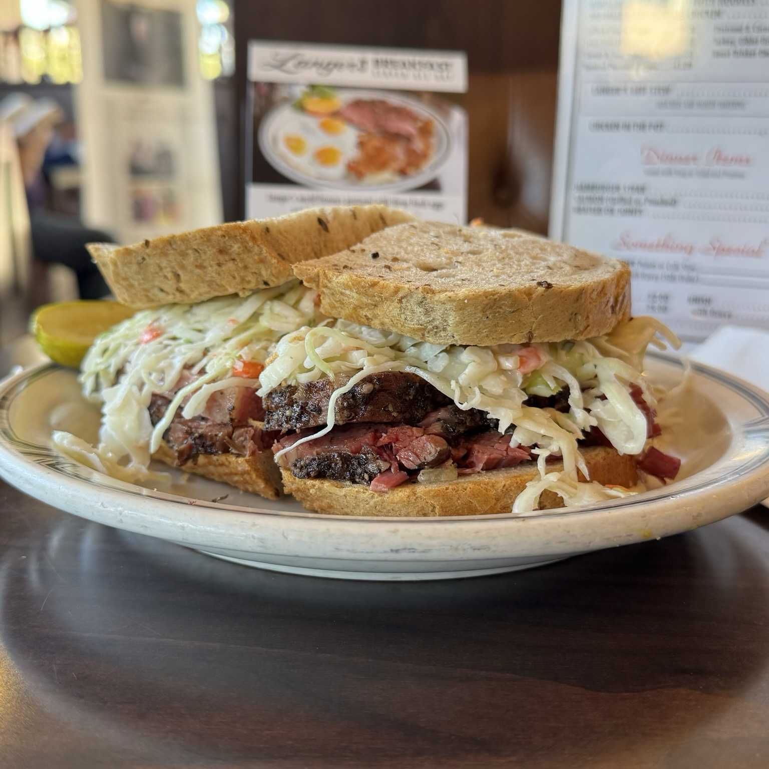 "The No. 19 at Norm Langer’s Westlake landmark should be named the official sandwich of Los Angeles. The pastrami — brined, peppered, smoked, steamed and shaved by hand into rosy kerchiefs — rises from between two slices of double-baked rye bread. A cushion of coleslaw, Swiss cheese and Russian dressing hovers over top like an upper bunk. Your senses are keener in the face of such perfection." https://www.langersdeli.com/