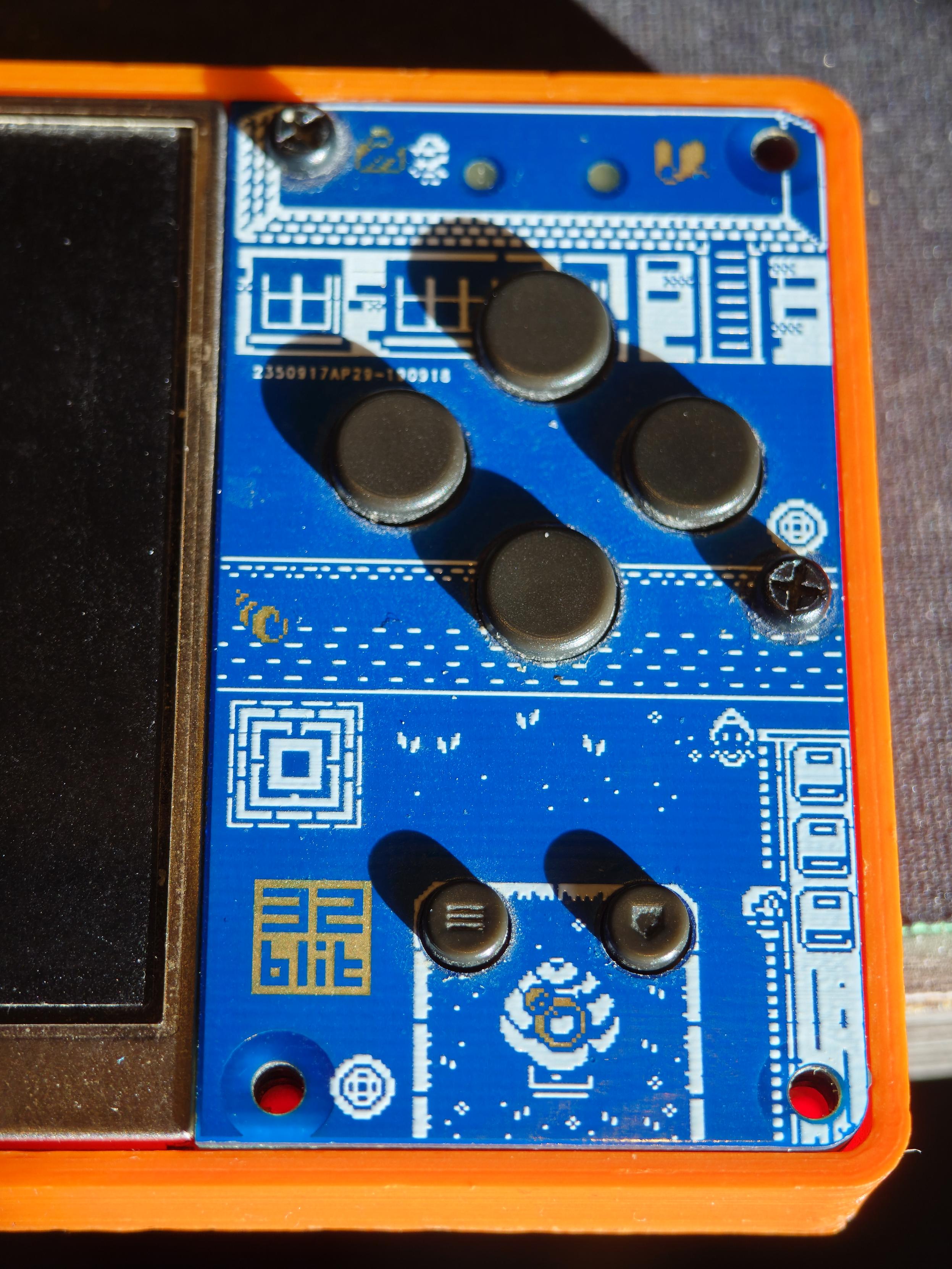 The right side of a 32blit beta unit. Looking past the PCB artwork and bright orange 3D-printed case, you may notice that the "home" button is upside-down.